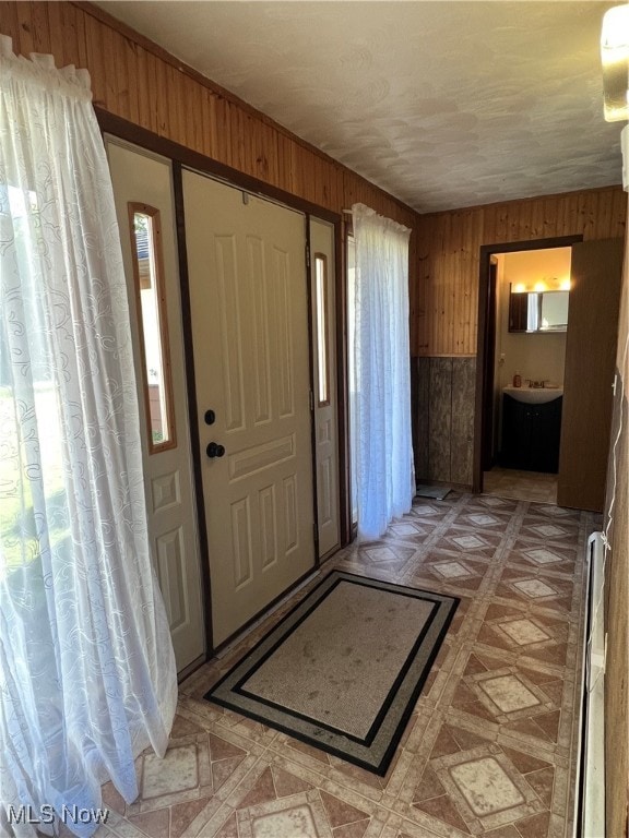 foyer featuring wooden walls