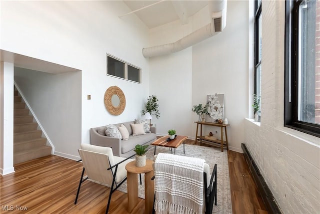 1133 W 9th St Unit 701, Cleveland, OH 44113 - living area with wood finished floors, stairway, baseboards, and a towering ceiling