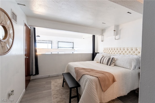 bedroom featuring a textured ceiling and hardwood / wood-style floors