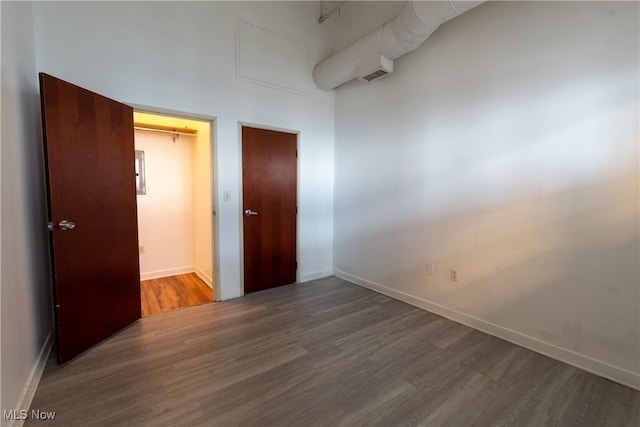 unfurnished bedroom with dark wood-type flooring and a closet