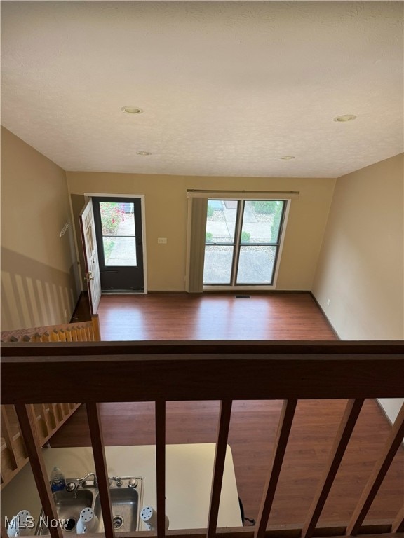 stairs with a healthy amount of sunlight and hardwood / wood-style floors