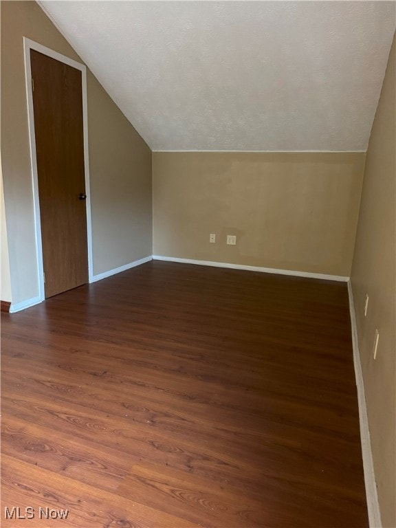 bonus room featuring vaulted ceiling and dark hardwood / wood-style flooring