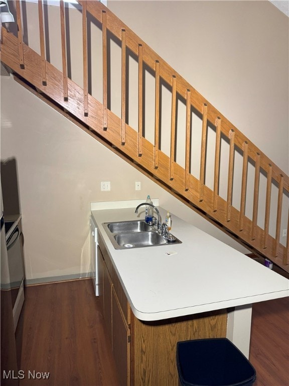 kitchen with a breakfast bar, dark wood-type flooring, and sink