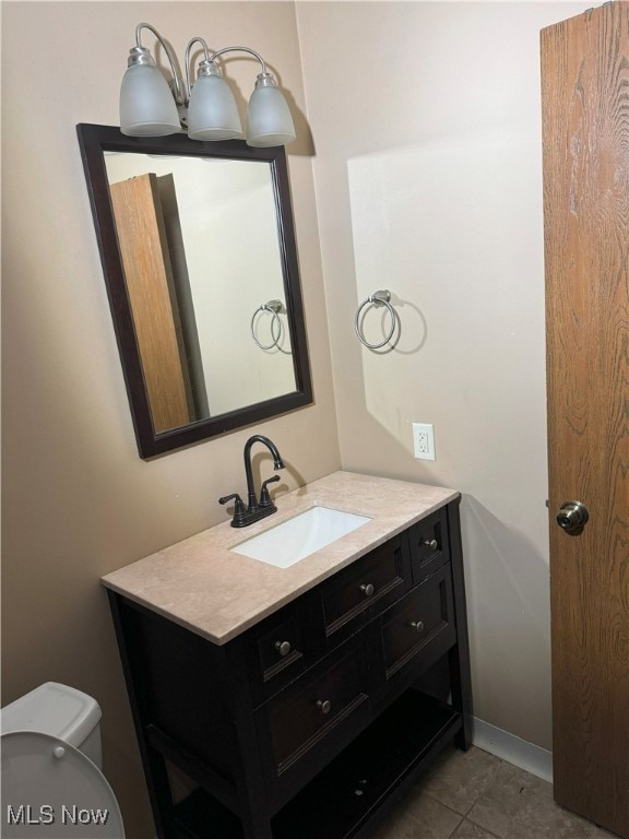 bathroom with tile patterned flooring, vanity, and toilet