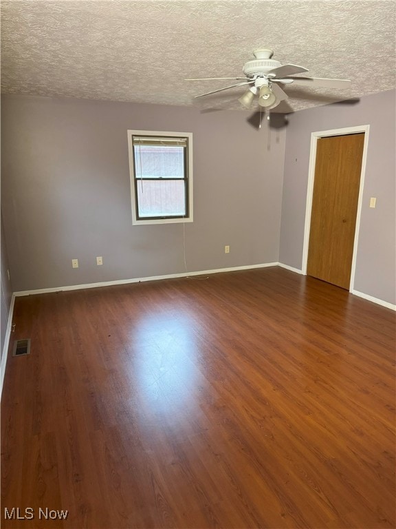 spare room featuring a textured ceiling, ceiling fan, and dark hardwood / wood-style flooring