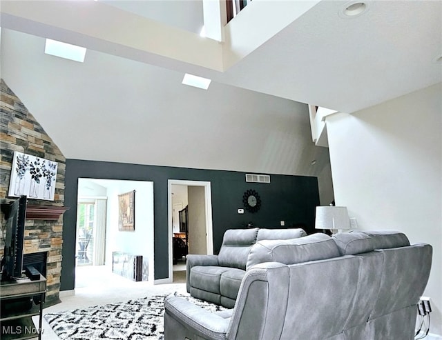 carpeted living room featuring a fireplace and high vaulted ceiling