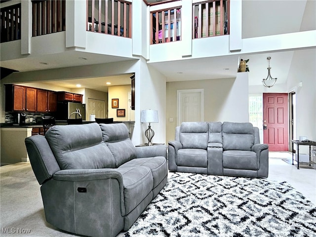 living room with light colored carpet and high vaulted ceiling