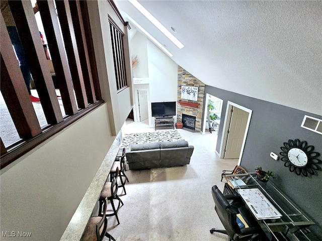 unfurnished bedroom with high vaulted ceiling, a textured ceiling, carpet floors, and a fireplace