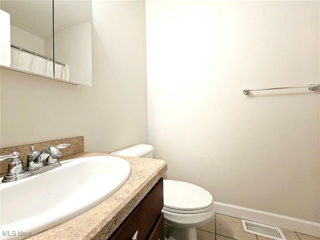 bathroom featuring tile patterned floors, vanity, and toilet