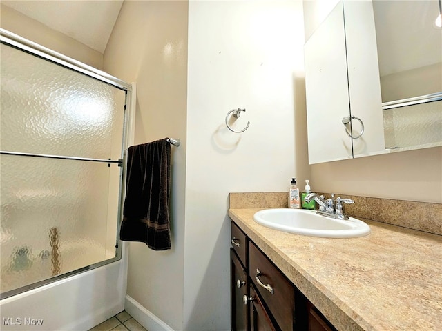 bathroom featuring vanity, tile patterned floors, and bath / shower combo with glass door