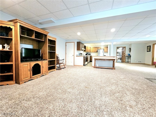 unfurnished living room featuring light colored carpet and a paneled ceiling