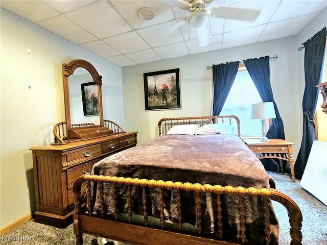 bedroom with ceiling fan, carpet flooring, and a paneled ceiling