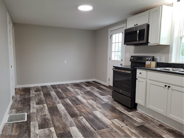 kitchen featuring white cabinets, black range with electric cooktop, dark hardwood / wood-style floors, and a healthy amount of sunlight