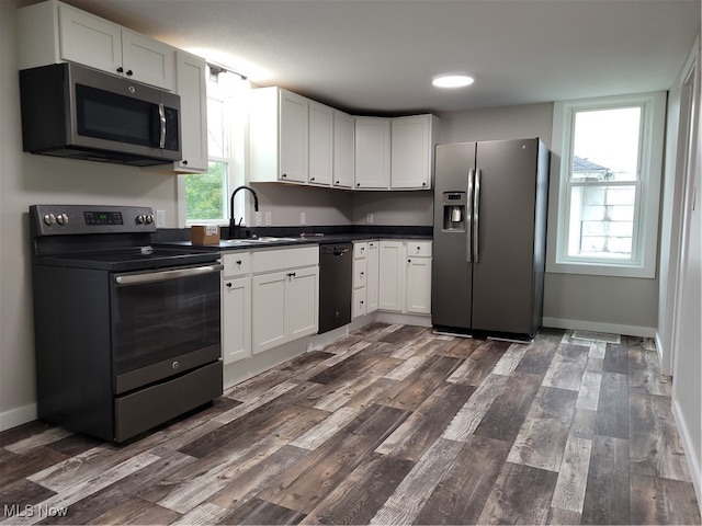 kitchen featuring white cabinets, appliances with stainless steel finishes, and plenty of natural light