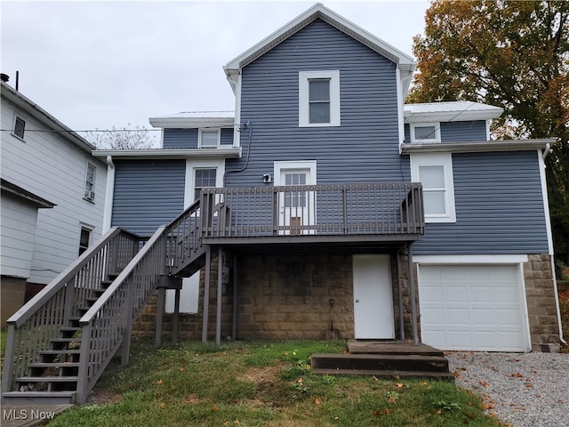 rear view of property with a garage and a wooden deck