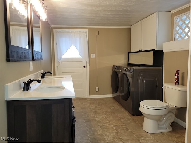 bathroom featuring independent washer and dryer, vanity, a textured ceiling, ornamental molding, and toilet