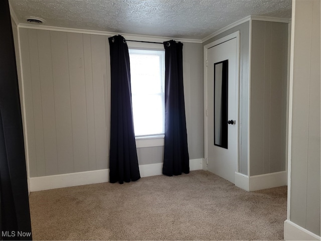 carpeted empty room with a textured ceiling