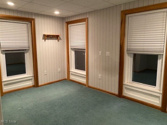 spare room featuring carpet floors and a drop ceiling