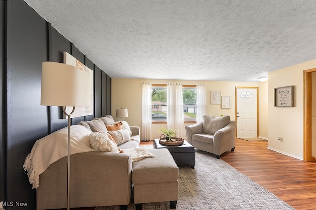 living room with a textured ceiling and hardwood / wood-style flooring