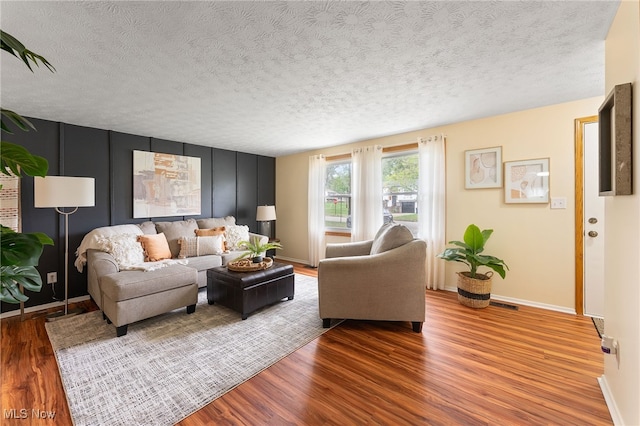 living room with a textured ceiling and hardwood / wood-style floors