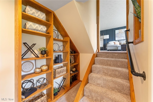 stairway featuring a textured ceiling