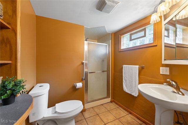 bathroom with sink, a shower with shower door, toilet, and tile patterned floors