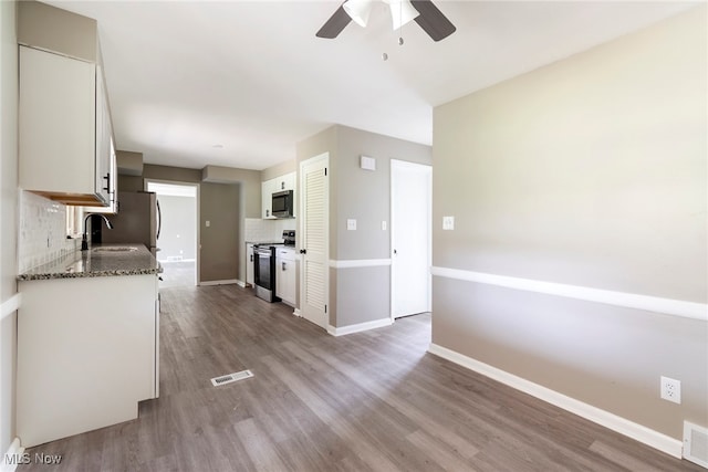 kitchen with decorative backsplash, stainless steel appliances, light hardwood / wood-style floors, and ceiling fan