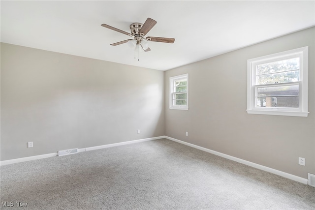 empty room featuring carpet, ceiling fan, and plenty of natural light