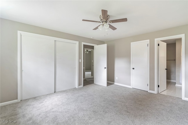 unfurnished bedroom with ceiling fan, ensuite bath, and light carpet