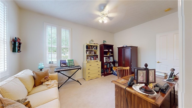 carpeted home office featuring ceiling fan