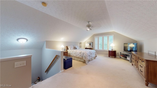 bedroom with a textured ceiling, vaulted ceiling, ceiling fan, and light colored carpet