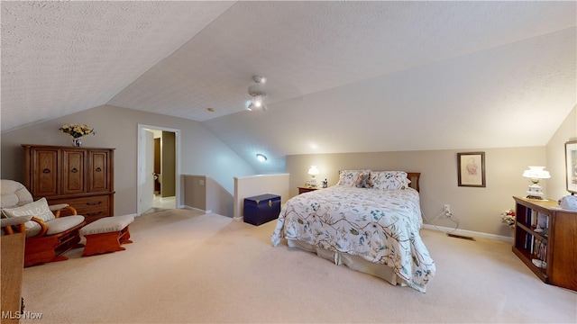 bedroom with light carpet, a textured ceiling, and vaulted ceiling