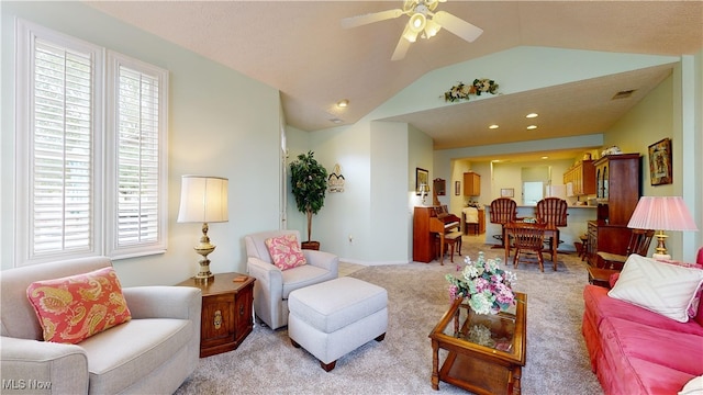 carpeted living room with ceiling fan and lofted ceiling