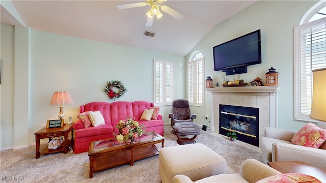 carpeted living room with a fireplace, lofted ceiling, and ceiling fan