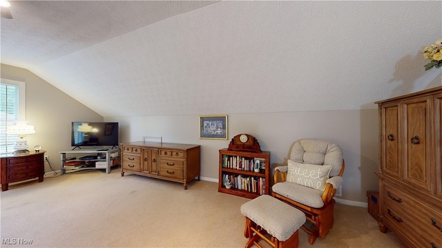 sitting room with light carpet, lofted ceiling, and a textured ceiling