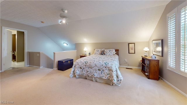 carpeted bedroom featuring a textured ceiling, vaulted ceiling, and ceiling fan