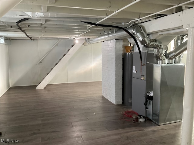 basement with heating unit and dark hardwood / wood-style floors