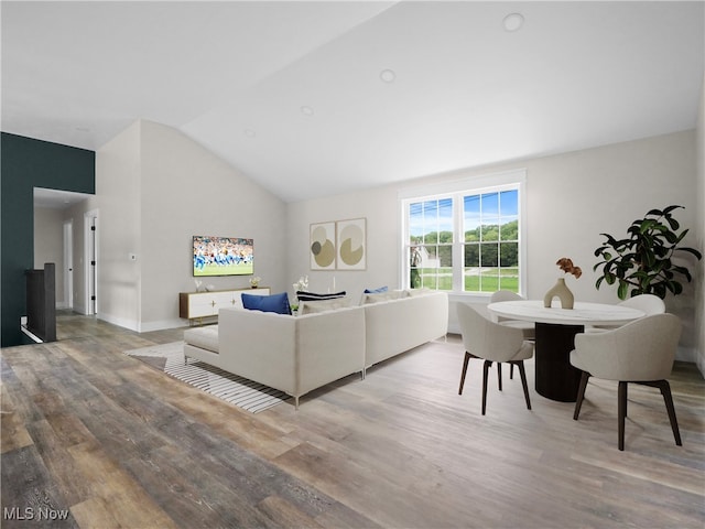 living room with light hardwood / wood-style floors and lofted ceiling