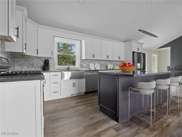 kitchen featuring sink, stainless steel appliances, dark hardwood / wood-style flooring, a kitchen bar, and white cabinets