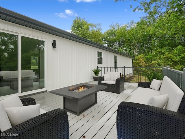 deck featuring an outdoor living space with a fire pit