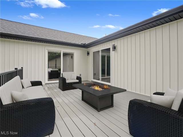 deck with an outdoor living space with a fire pit