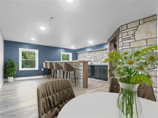 dining area featuring bar area and light hardwood / wood-style flooring