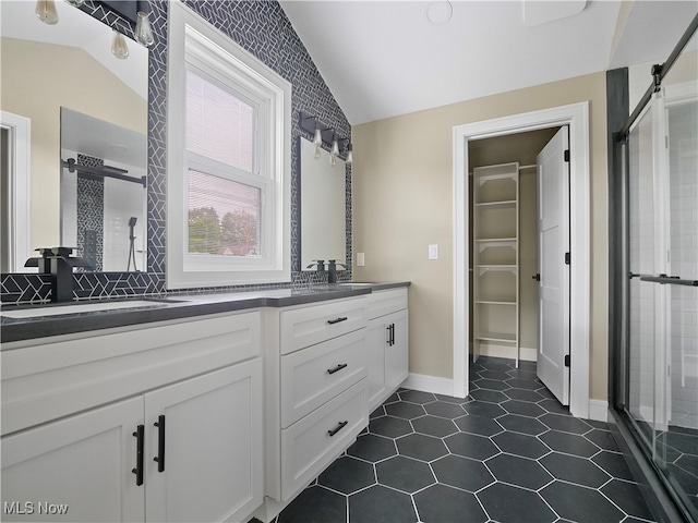 bathroom featuring tile patterned floors, vanity, an enclosed shower, and lofted ceiling