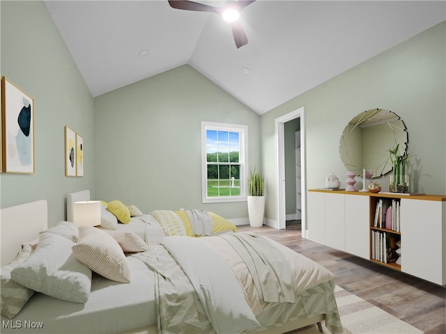 bedroom featuring ceiling fan, light hardwood / wood-style floors, and lofted ceiling