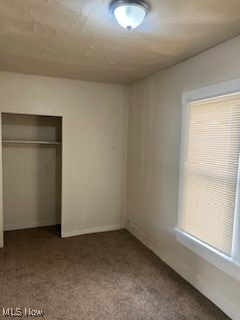 unfurnished bedroom featuring a closet and carpet floors