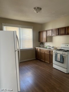 kitchen with dark hardwood / wood-style flooring and white appliances