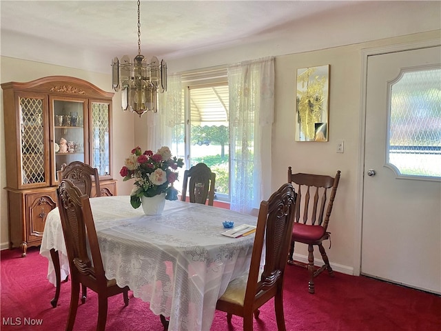 dining space with carpet and an inviting chandelier