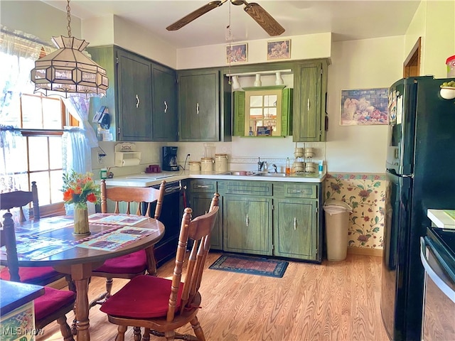 kitchen featuring black appliances, sink, a healthy amount of sunlight, and light hardwood / wood-style floors