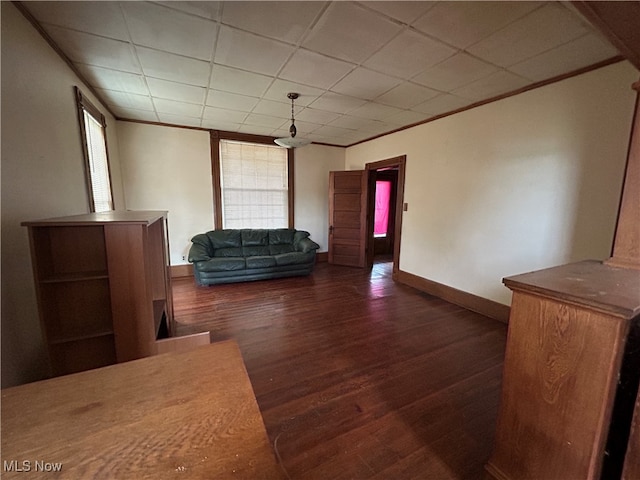 interior space featuring a paneled ceiling and dark wood-type flooring