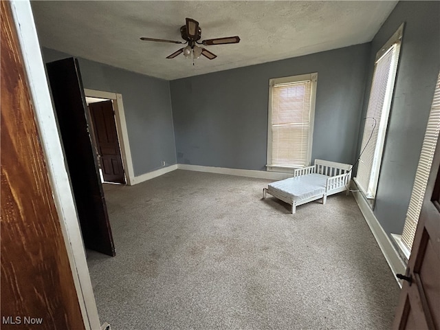 carpeted empty room featuring a textured ceiling and ceiling fan